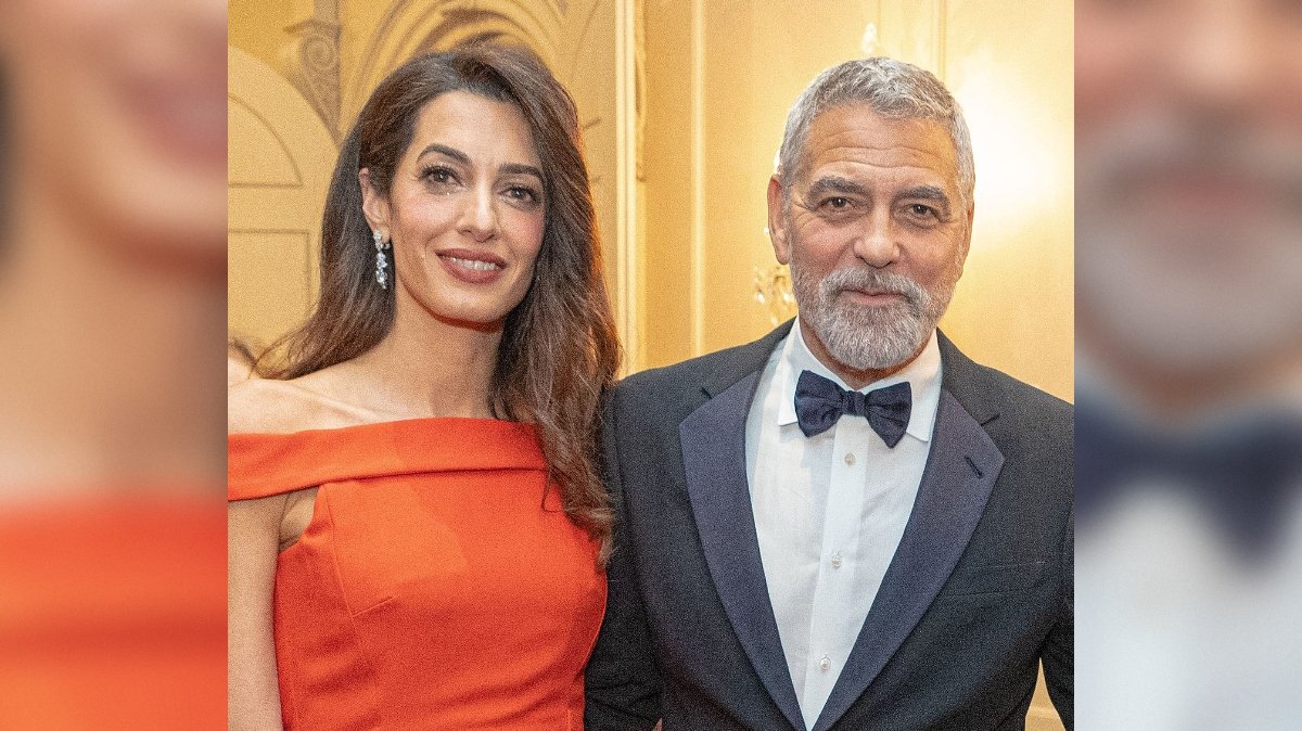 Amal Clooney and George Clooney pose together at a formal event, showcasing elegant attire and a sophisticated atmosphere.