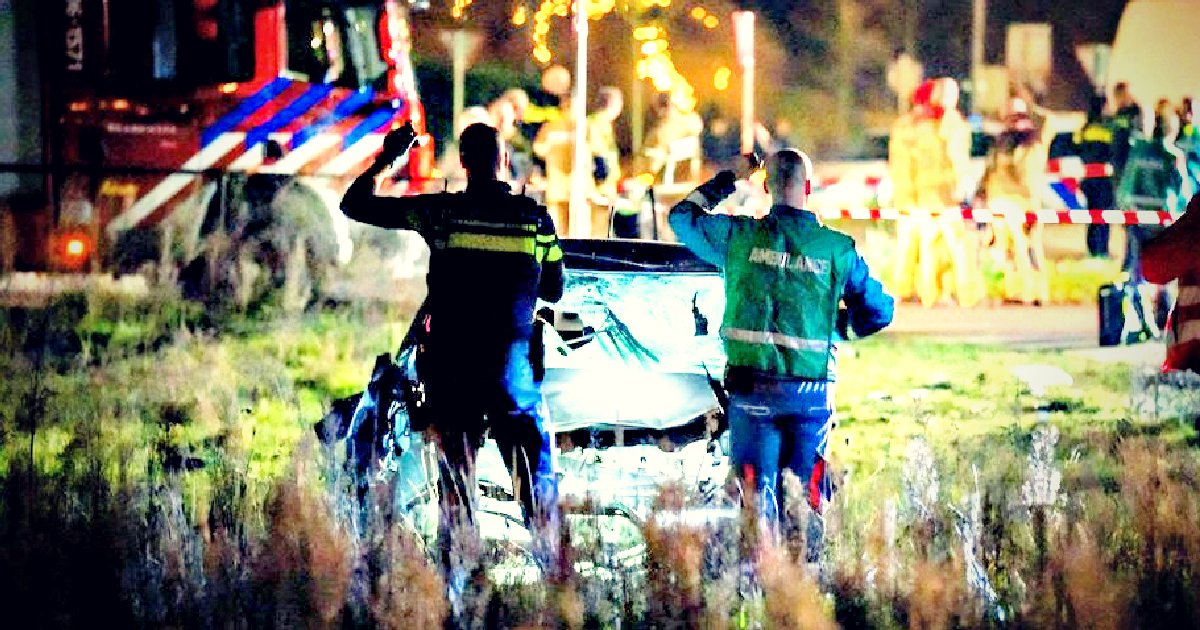Emergency responders assess a serious car accident scene at night, with a damaged vehicle and emergency personnel in the background.