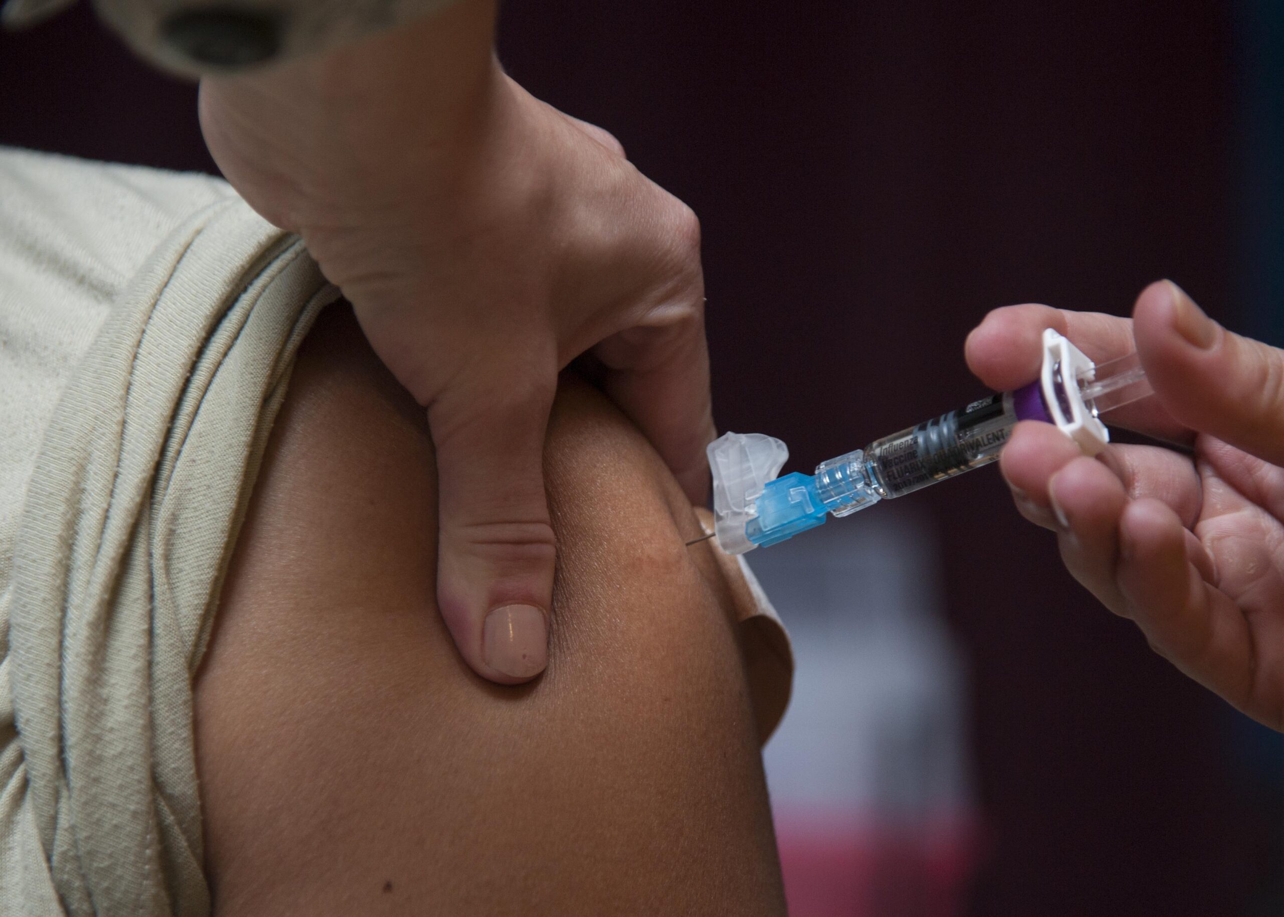 A healthcare professional administering a vaccine injection into a patient's upper arm, emphasizing the importance of immunization for health.