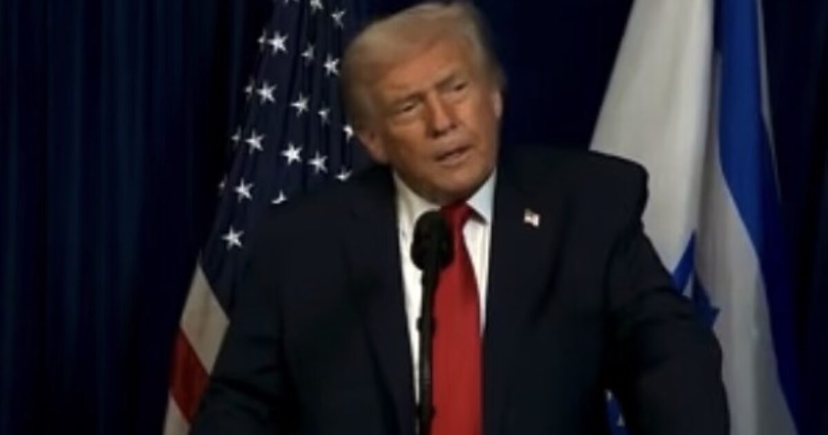 Former President Donald Trump speaking at a podium with American and Israeli flags in the background.