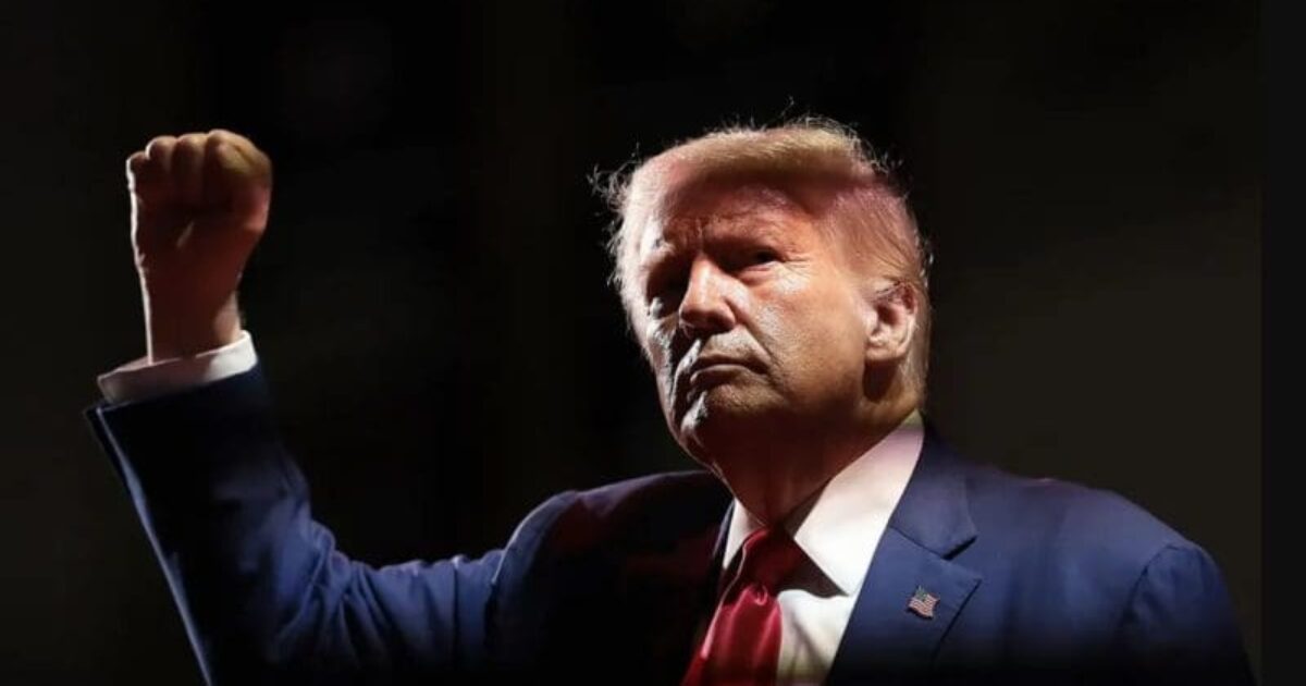 Donald Trump delivering a powerful speech, raising his fist in a show of determination and leadership against a dark background.