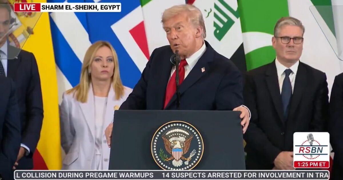 Former President Donald Trump speaks at a podium during an event in Sharm El-Sheikh, Egypt, surrounded by international leaders and flags.