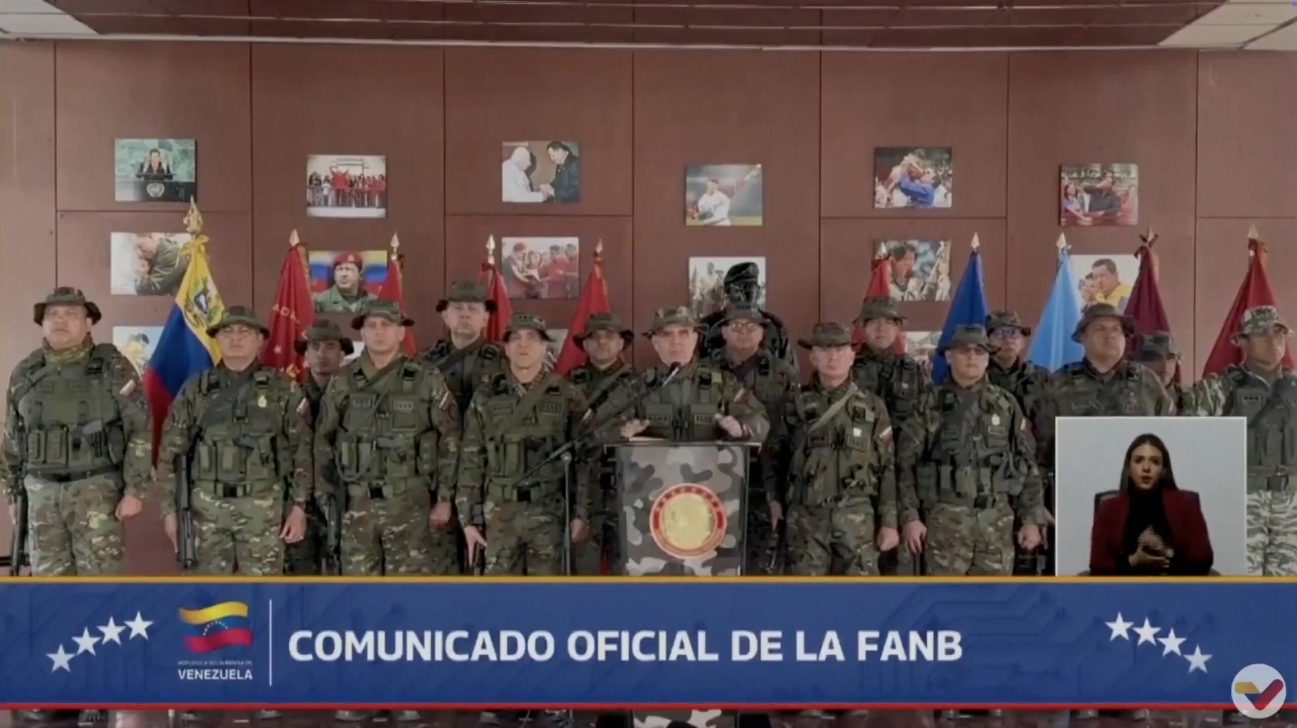 Venezuelan military officials gather for an official communication, showcasing flags and military attire, with a sign language interpreter in the corner.