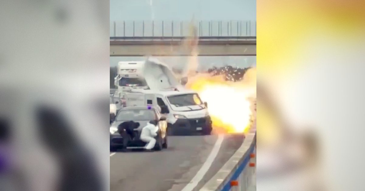 Explosion on a highway involving a white van and a black car, with individuals taking cover nearby.