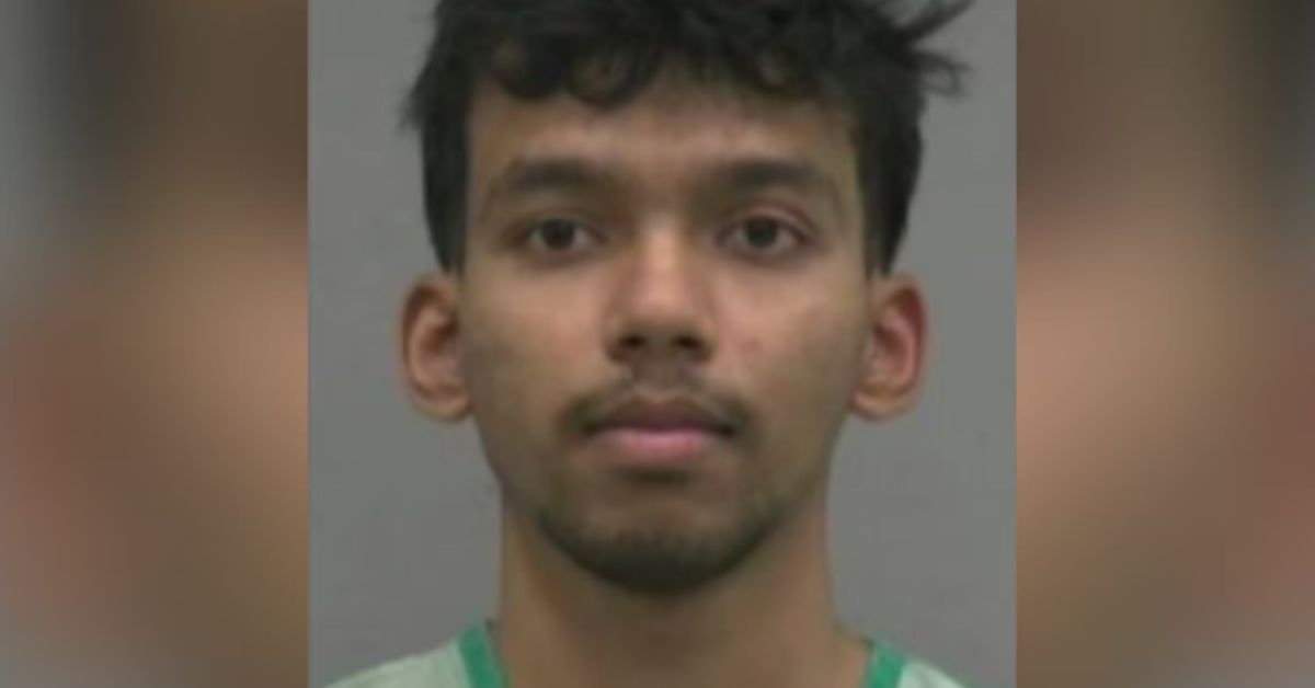 Mugshot of a young man with curly hair wearing a green shirt, facing the camera against a neutral background.