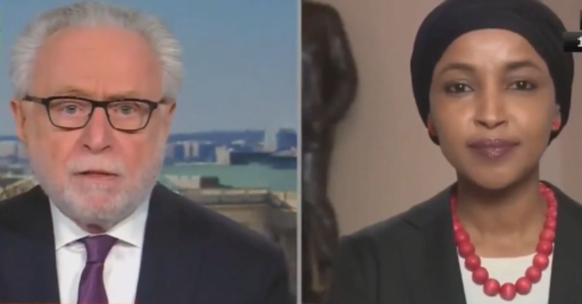 Wolf Blitzer interviews Ilhan Omar during a news segment, discussing current political topics with a cityscape backdrop.