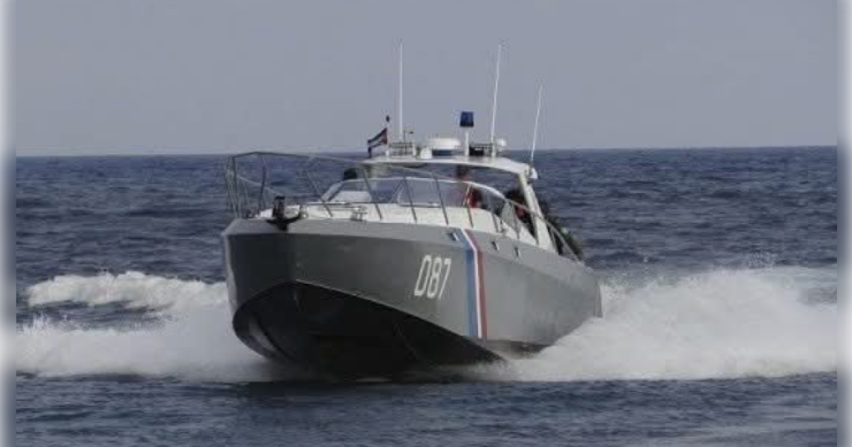 Gray patrol boat with the number 087 speeding across the ocean, creating waves and showcasing maritime security operations.