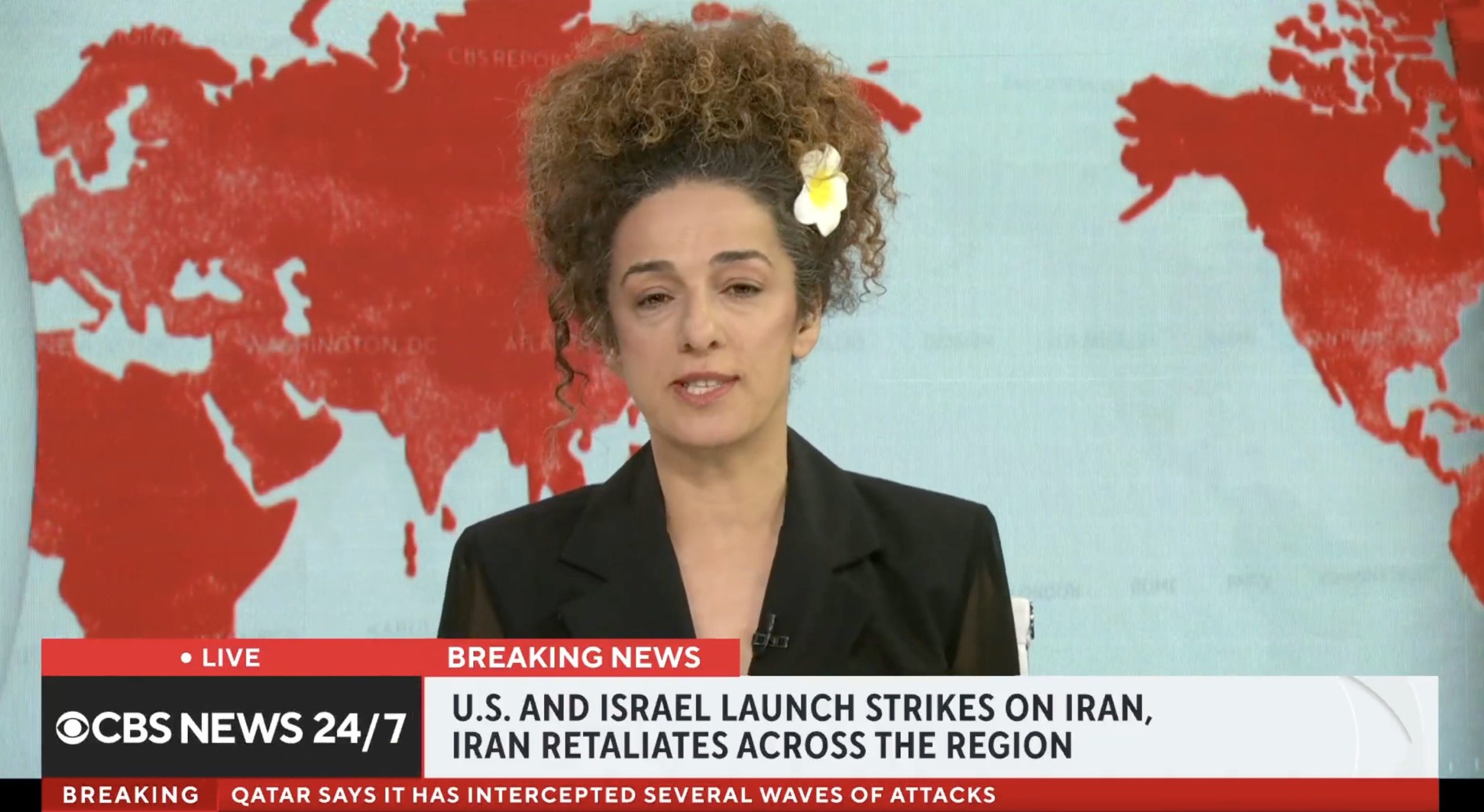 News anchor reporting on breaking news regarding U.S. and Israel strikes on Iran, with a world map background highlighting the region.
