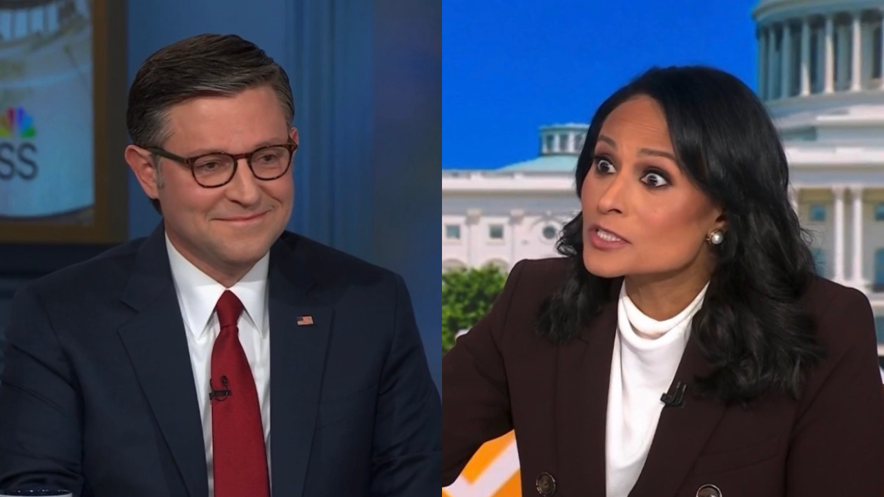 Two news commentators engaged in a discussion on a television set, one smiling and the other animatedly expressing a point.