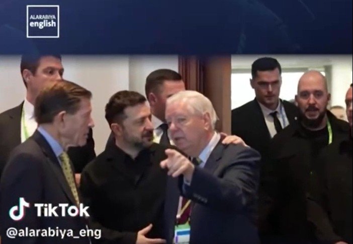 Group of officials engaged in conversation at a formal event, with security personnel in the background, highlighting a moment of interaction and discussion.