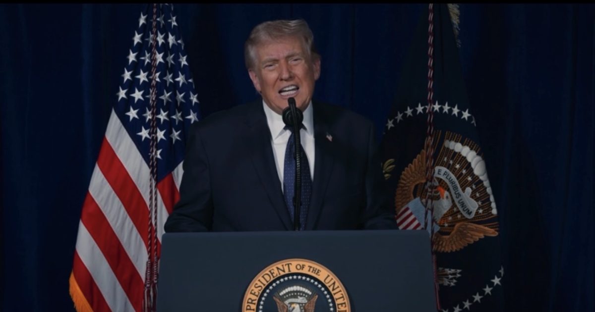 Donald Trump speaking at a podium with the presidential seal, flanked by American flags during an official event.