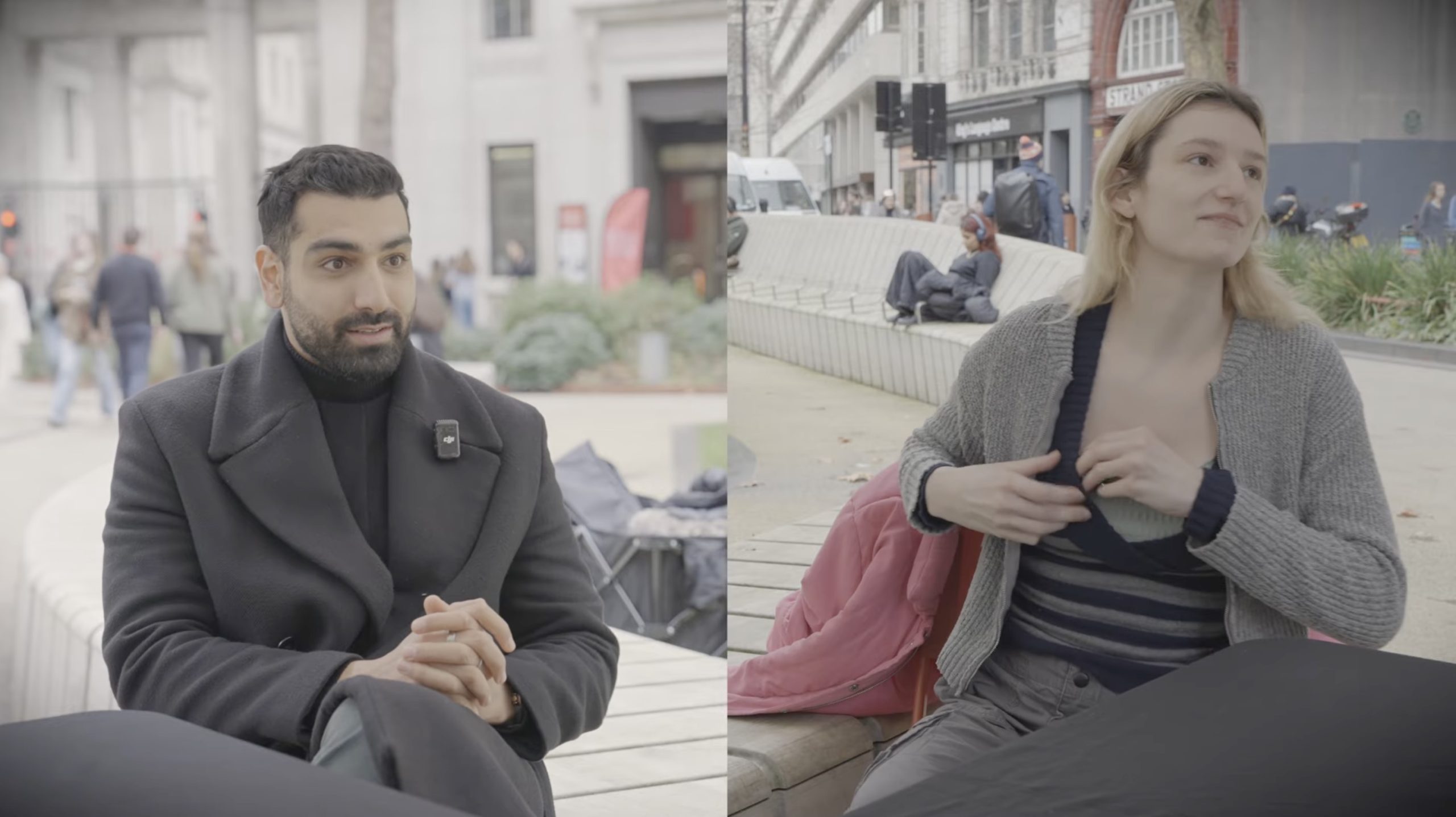 Two individuals engage in conversation outdoors, with a cityscape in the background, showcasing a casual and relaxed atmosphere.