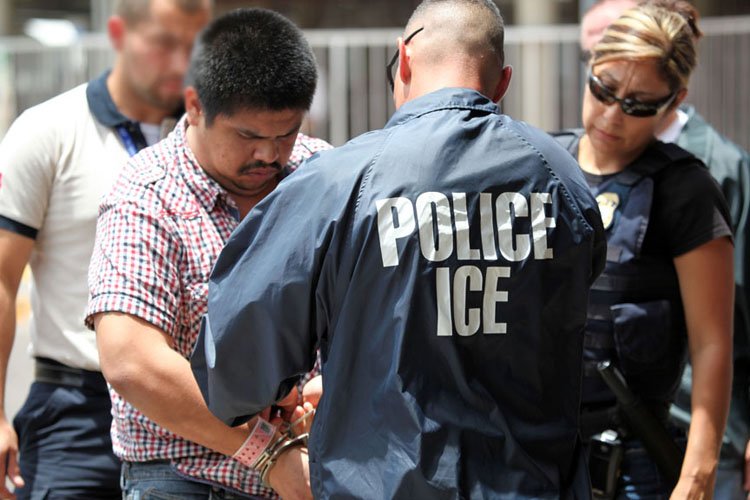 ICE agents arrest an individual in a public setting, highlighting immigration enforcement operations.