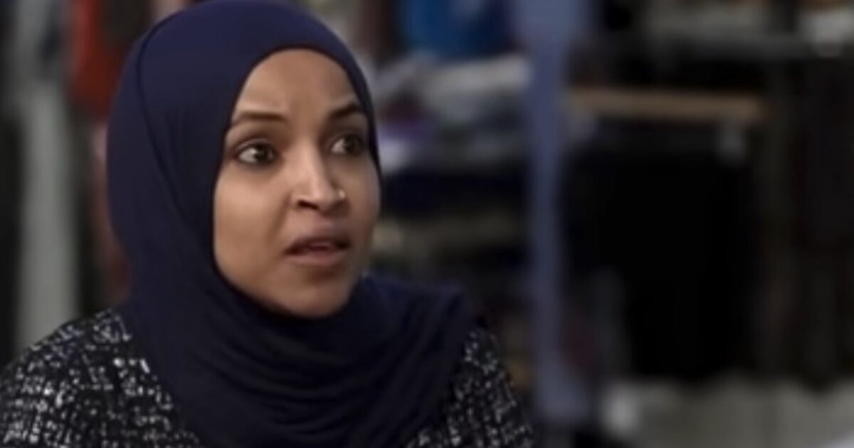 Woman in a hijab expressing concern during an interview, with a blurred retail background.