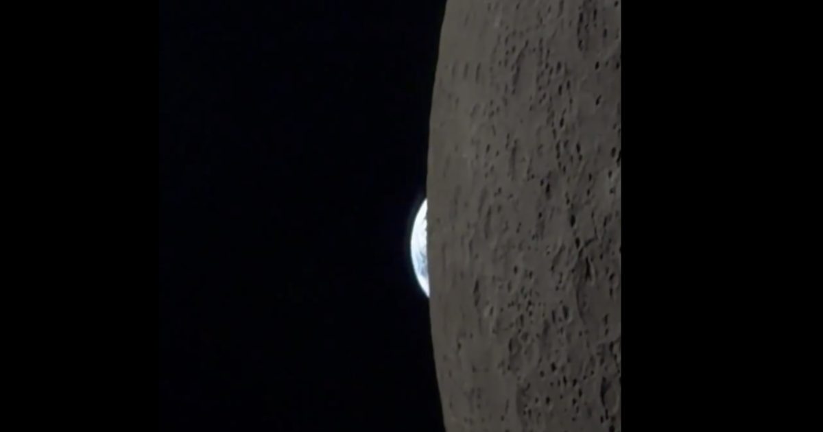 Earth rising over the lunar surface, showcasing the textured moon landscape against a dark space backdrop.