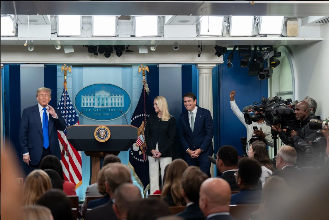 Former President Donald Trump speaks at a White House press conference, flanked by officials and surrounded by journalists capturing the event.