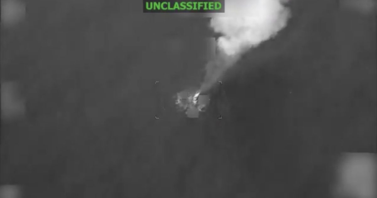 Aerial view of a military operation showing a smoke plume, captured in unclassified infrared footage.
