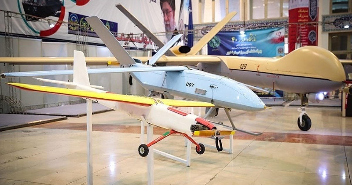 Display of various unmanned aerial vehicles (UAVs) including a small drone and larger models at an exhibition, showcasing advancements in drone technology.