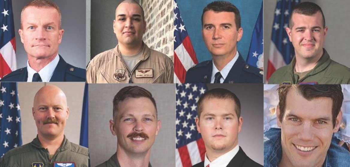 Group portrait of eight military personnel in uniform, showcasing diverse roles and backgrounds, with American flags in the background.