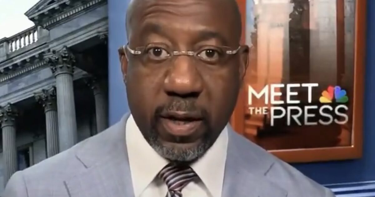 Man in a light blue suit speaking on a news program with a backdrop of a government building and "Meet the Press" logo.