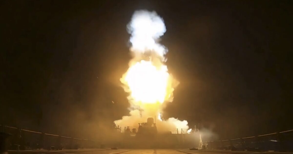 Naval ship launching a missile at night, with flames and smoke visible against a dark background.